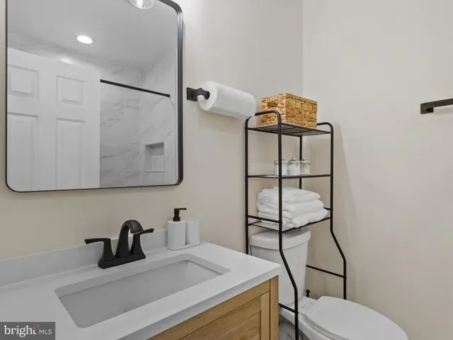 a bathroom with a sink vanity mirror and toilet