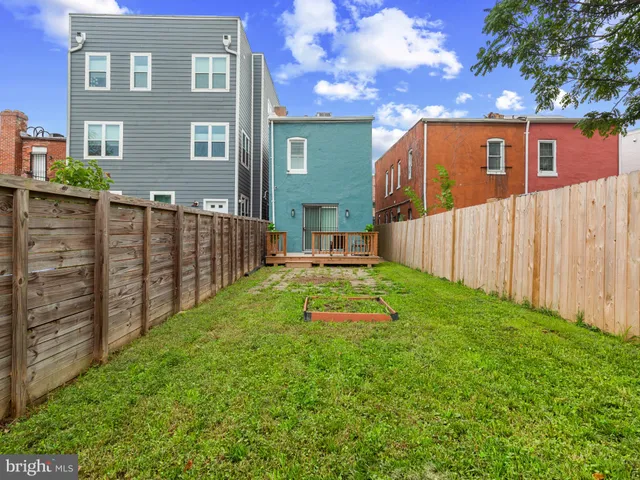 a view of backyard with garden and wooden fence