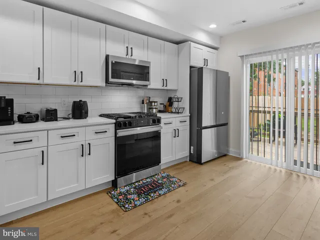 a kitchen with stainless steel appliances granite countertop a refrigerator stove top oven and sink