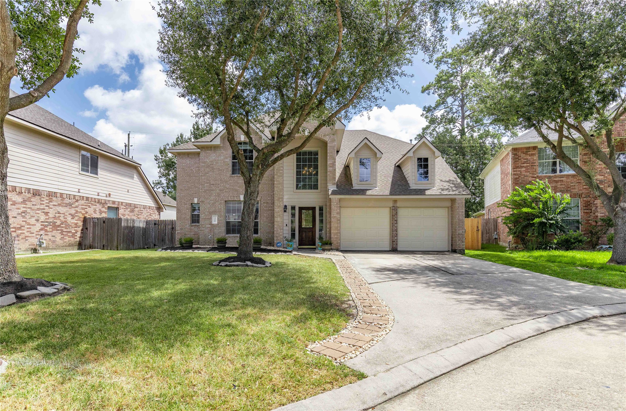 24506 Fort Path Drive Spring, TX 77373 - Photo 44 of 46 Charming two-story brick home with a spacious driveway, nestled between mature trees and offering a well-maintained front lawn.