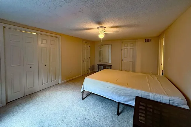 a spacious bedroom with a bed and a chandelier