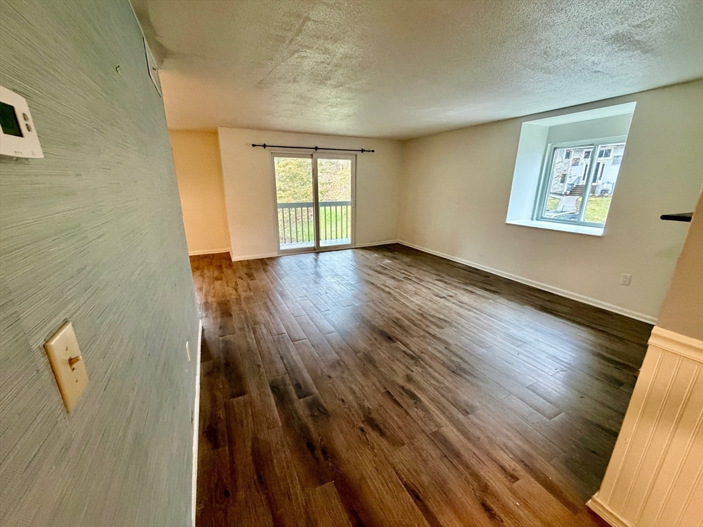13 Beal's Cove Road, Unit K Hingham, MA 02043 - Photo 6 of 7 a view of an empty room with wooden floor and a window
