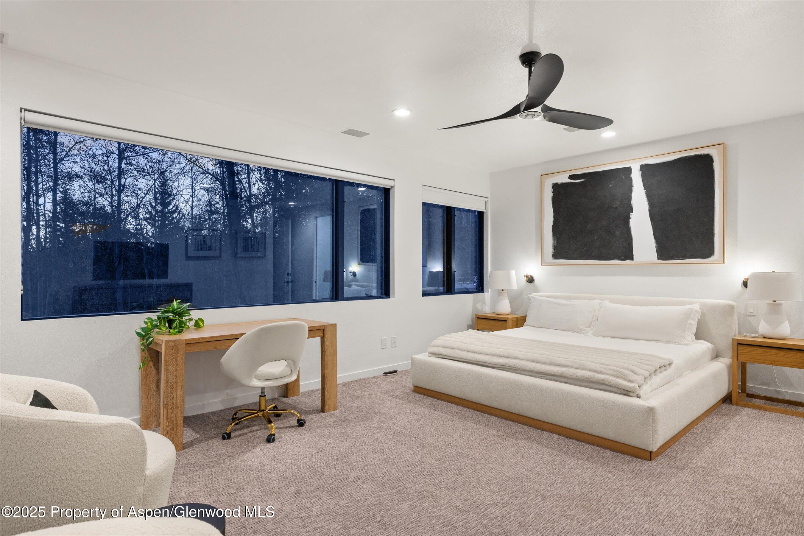 233 Stellar Lane Snowmass Village, CO 81615 - Photo 19 of 43 a spacious bedroom with a bed a couch and a large window