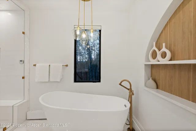 a white bath tub sitting next to a shower