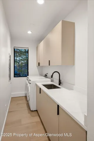 a view of a kitchen with kitchen island a sink wooden floor and a large window