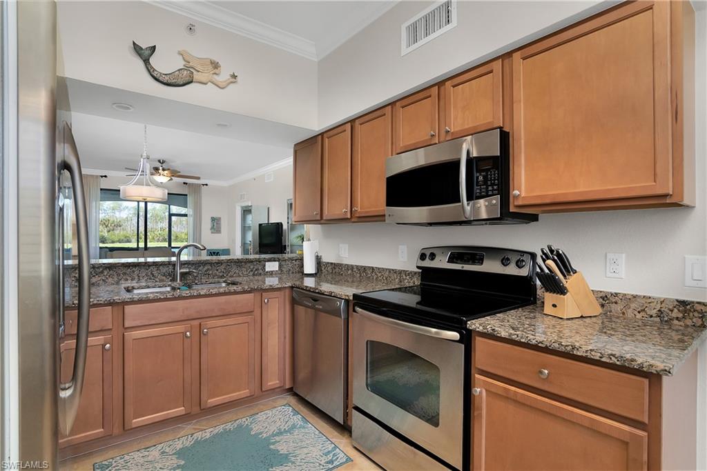 9719 Acqua Court, Unit 214 Naples, FL 34113 - Photo 14 of 50 a kitchen with stainless steel appliances granite countertop a sink and a stove top oven