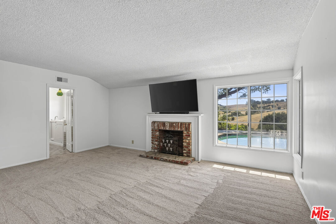 24962 Eldorado Meadow Road Hidden Hills, CA 91302 - Photo 8 of 19 a view of an empty room with a window and fireplace