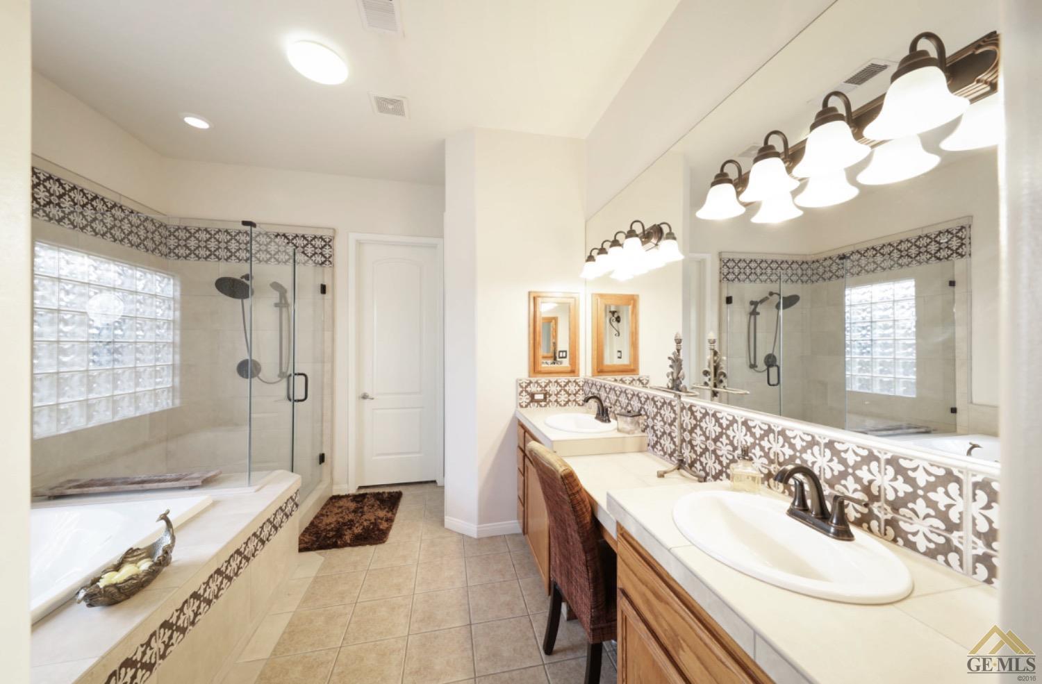 Undisclosed Address Bakersfield, CA 93314 - Photo 15 of 31 a spacious bathroom with a double vanity sink mirror and shower