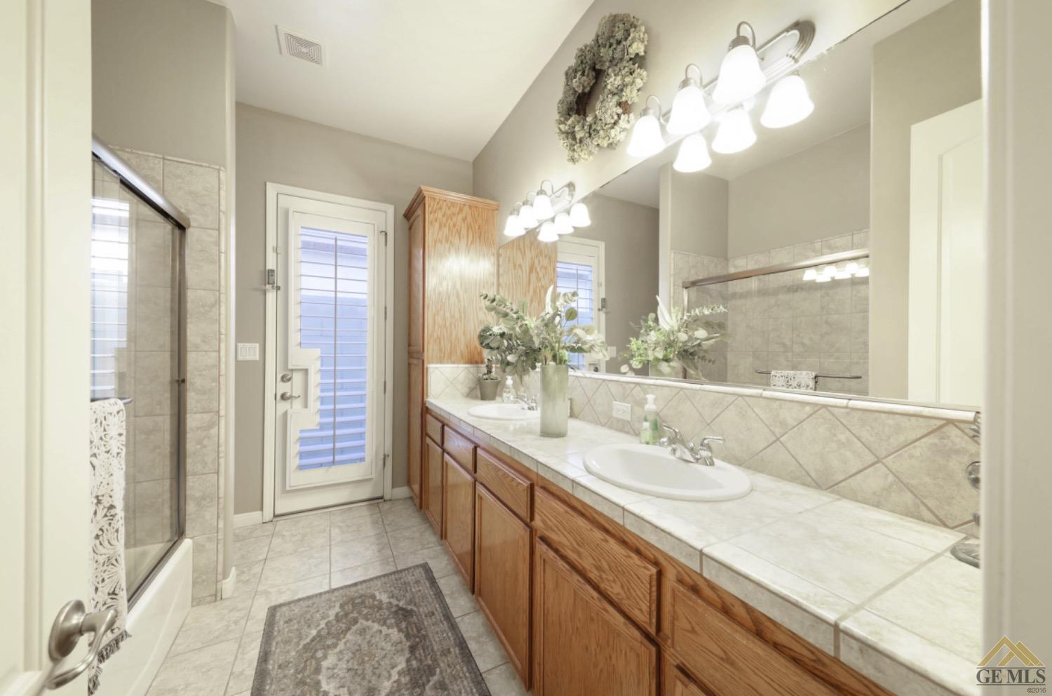 Undisclosed Address Bakersfield, CA 93314 - Photo 23 of 31 a bathroom with a sink a mirror and a shower