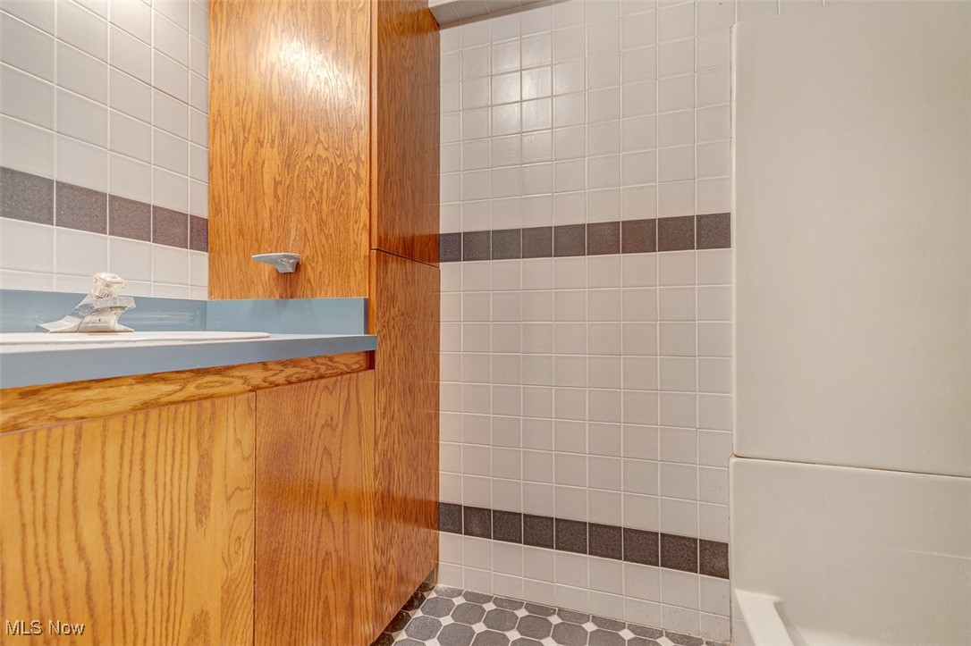 6136 Ridge Road Cleveland, OH 44129 - Photo 34 of 40 Bathroom featuring tile walls and vanity