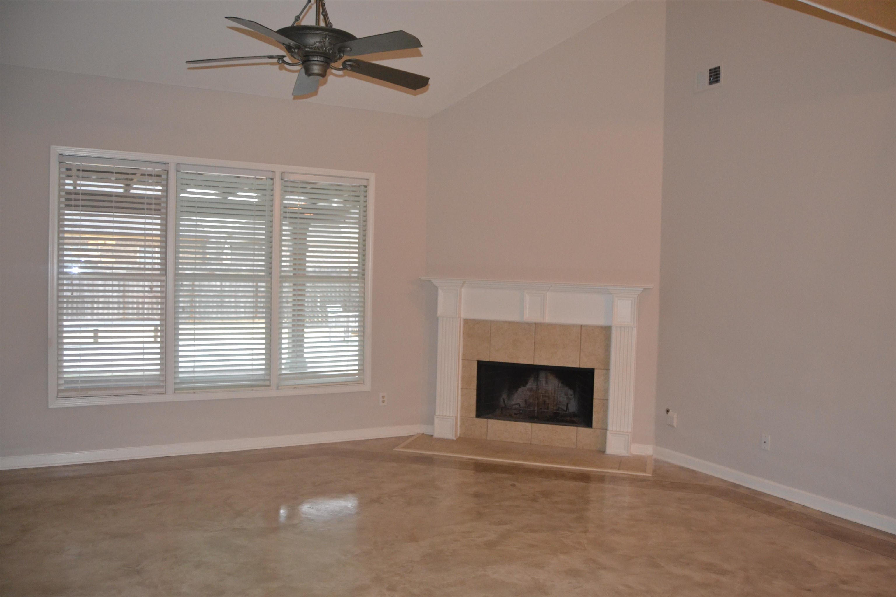10486 Juneau Way Collierville, TN 38017 - Photo 4 of 33 Unfurnished living room featuring a fireplace, lofted ceiling, ceiling fan, and a healthy amount of sunlight