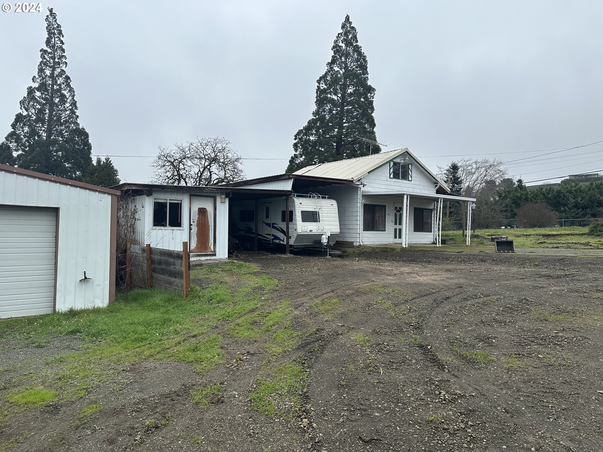 5114 Southwest Grange Road Roseburg, OR 97471 - Photo 2 of 11 a front view of a house with a garden and trees
