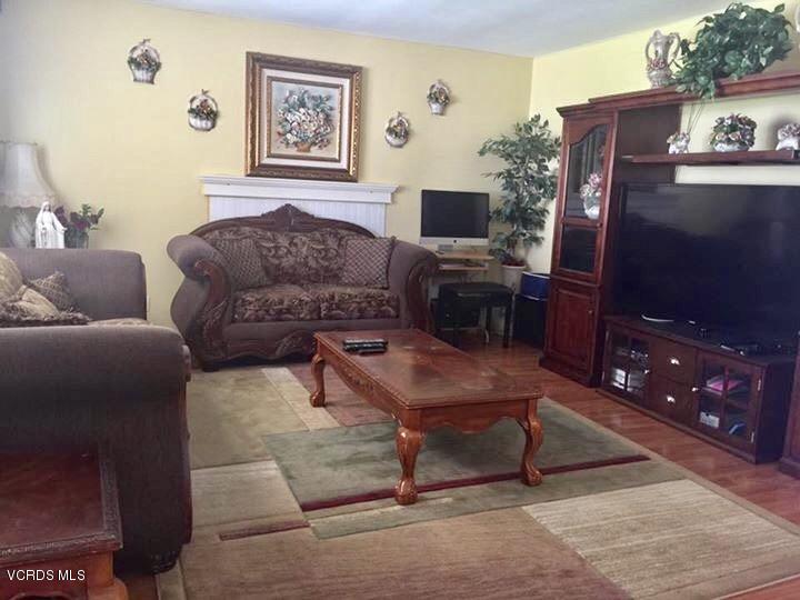 310 Fairbourne Place Oxnard, CA 93033 - Photo 3 of 7 a living room with furniture a flat screen tv and a lamp