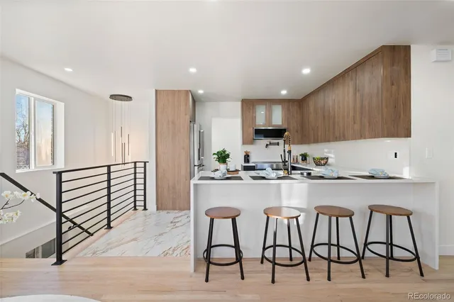 a kitchen with refrigerator and chairs