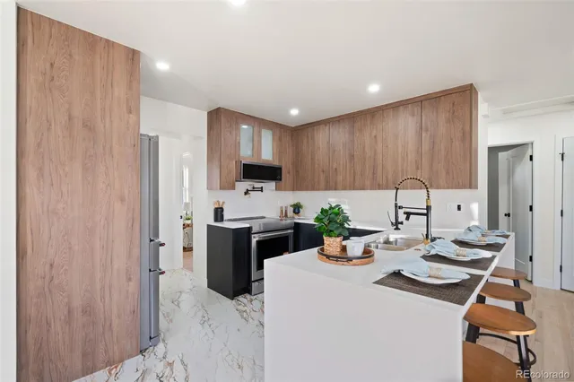 a kitchen with a sink a stove and chairs
