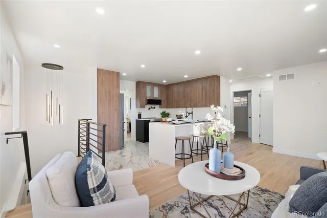 a living room with stainless steel appliances kitchen island furniture and a dining table with kitchen view