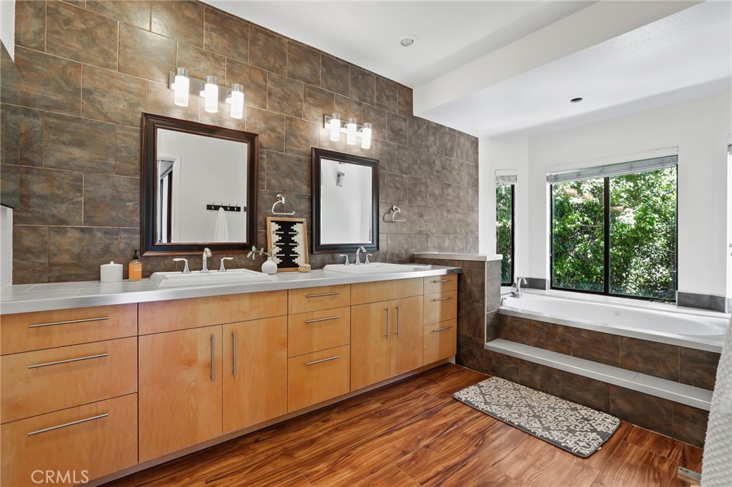 1862 Derby Drive North Tustin, CA 92705 - Photo 42 of 52 a bathroom with a double vanity sink a mirror and a bathtub