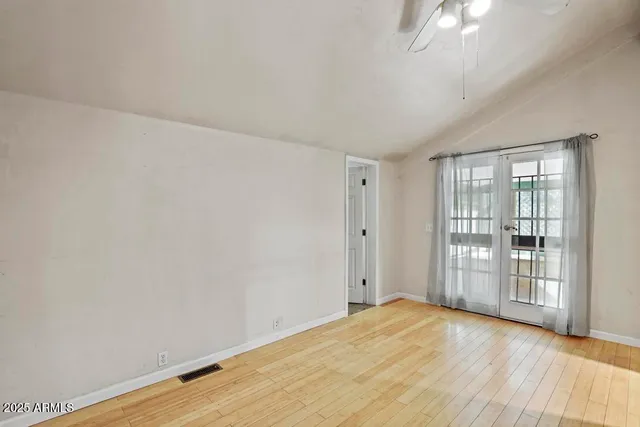 a view of empty room with wooden floor