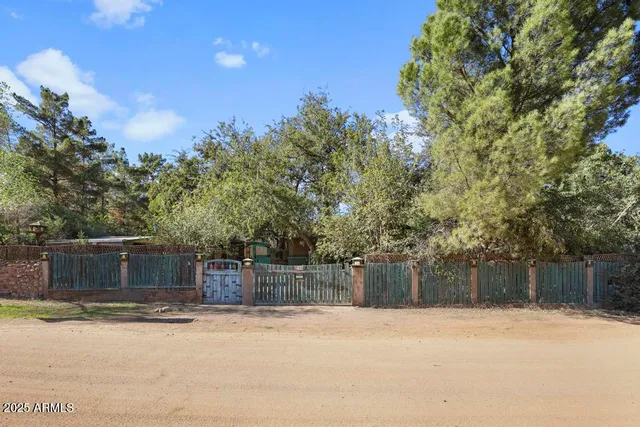 a backyard of a house with trees and covered with wooden fence