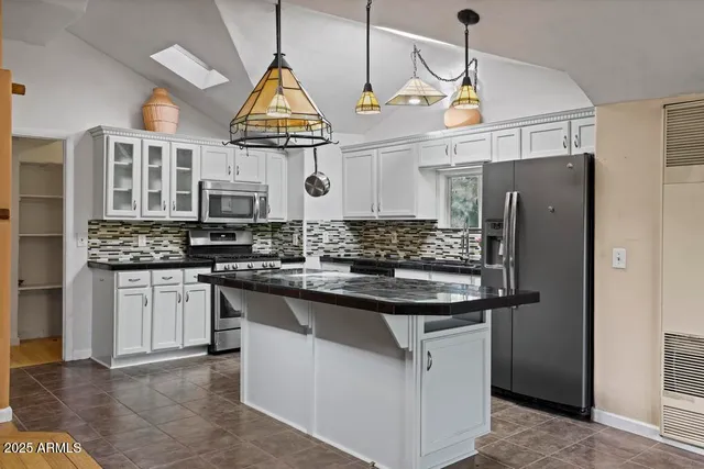 a kitchen with stainless steel appliances granite countertop a sink and refrigerator