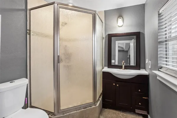 a bathroom with a sink a toilet and shower