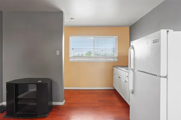 a kitchen with granite countertop cabinets and refrigerator
