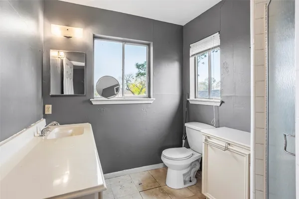 a bathroom with a toilet a sink and mirror