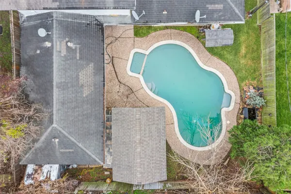 an aerial view of a house with swimming pool and garden