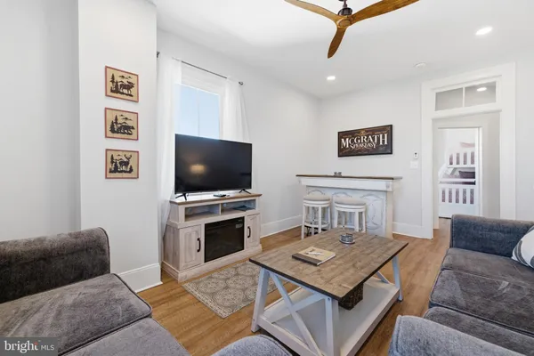 a living room with furniture and a wooden floor