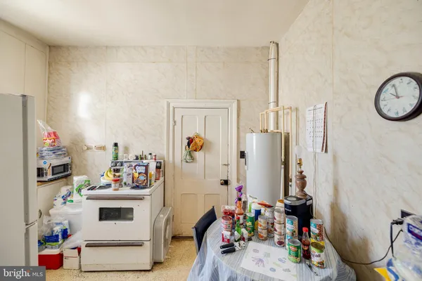 a kitchen with a refrigerator and a stove top open