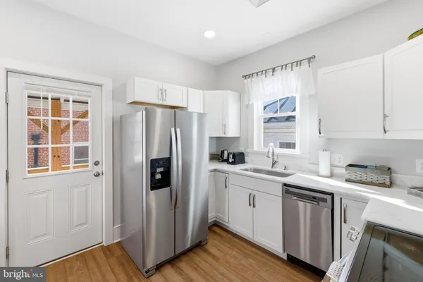 a kitchen with stainless steel appliances a refrigerator sink and cabinets