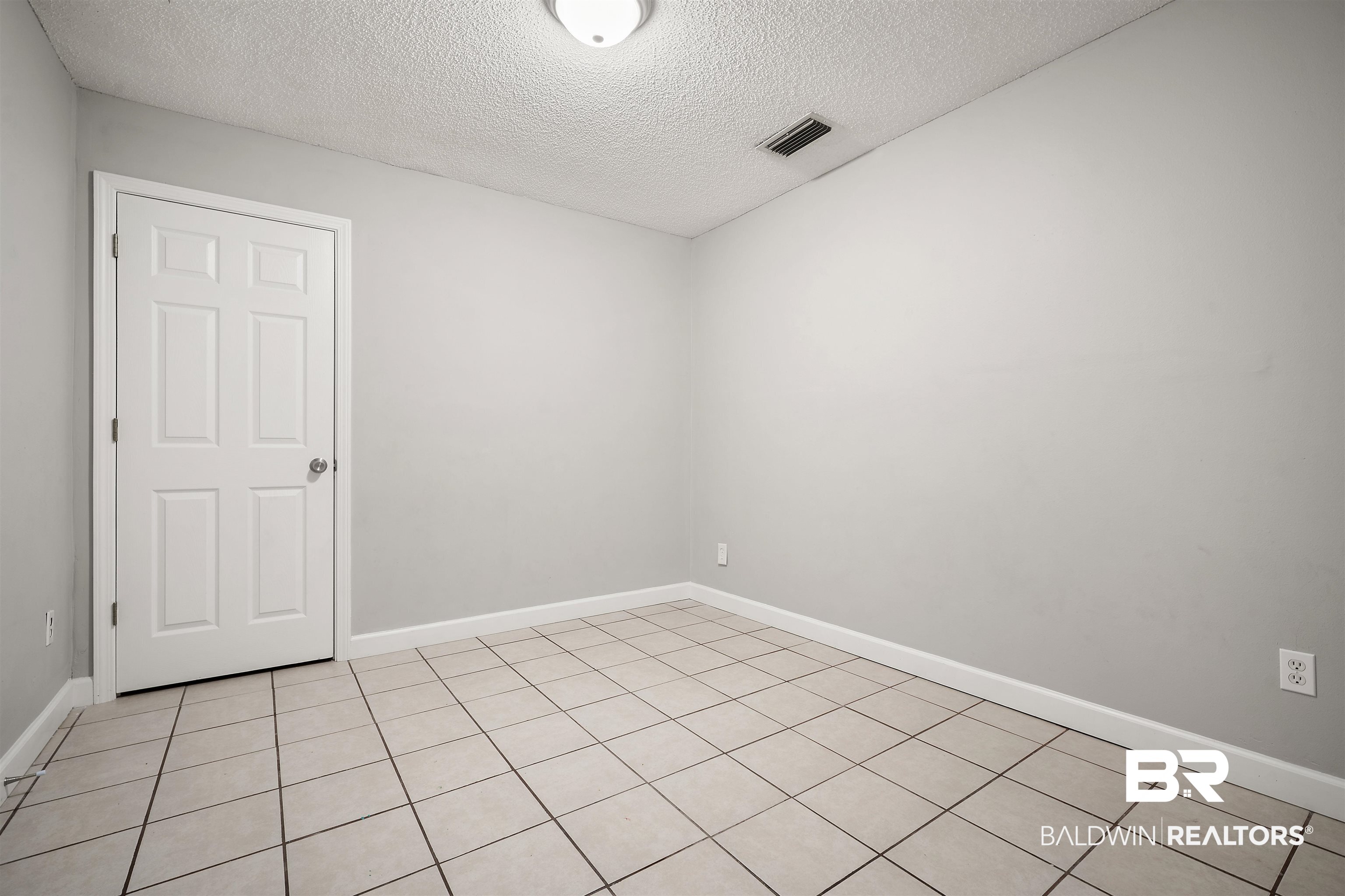 963 Shady Brook Drive Mobile, AL 36606 - Photo 16 of 20 Empty room with a textured ceiling, baseboards, and light tile patterned floors