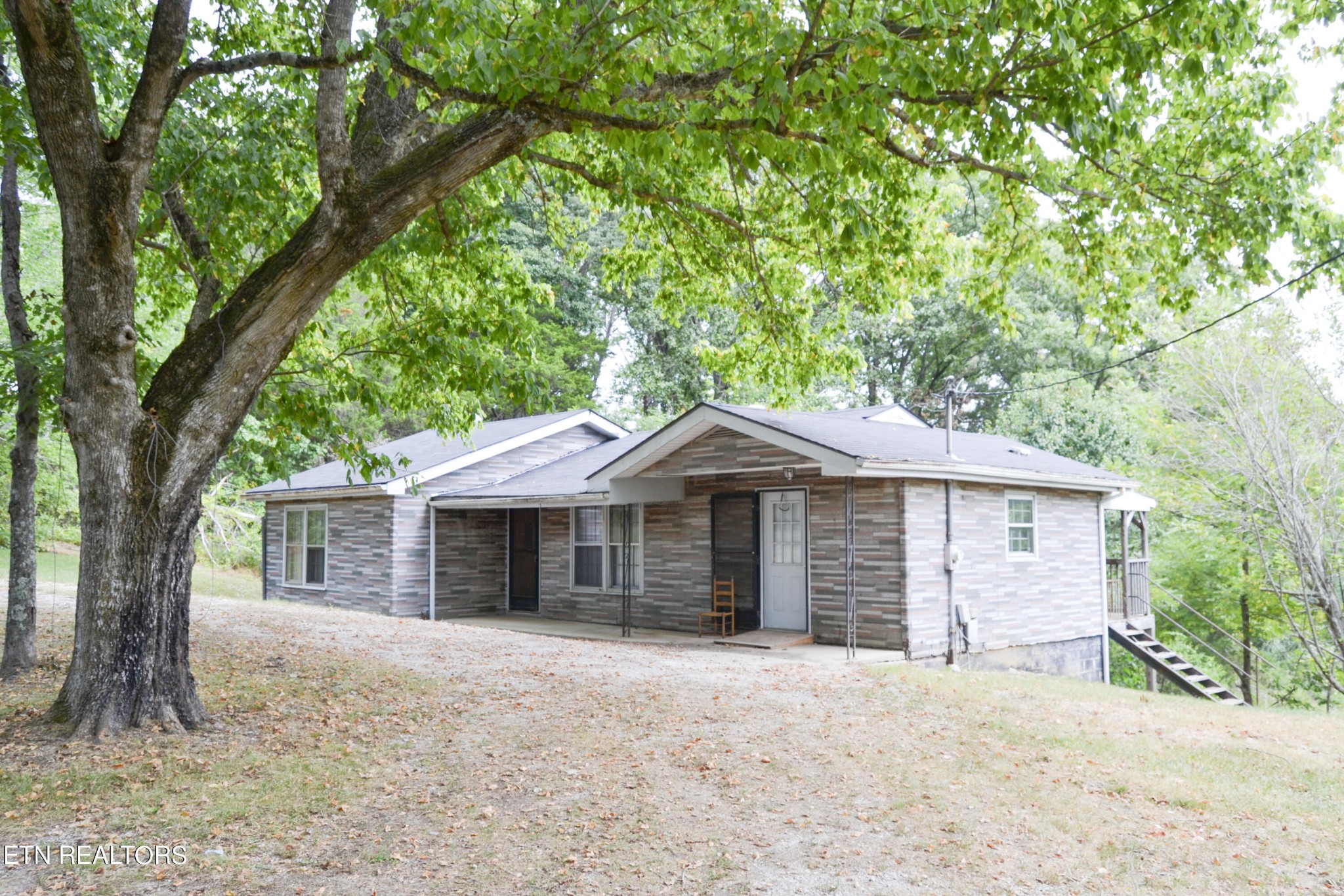 147 Tom Davis Road Livingston, TN 38570 - Photo 1 of 29 a front view of a house with a garden and trees