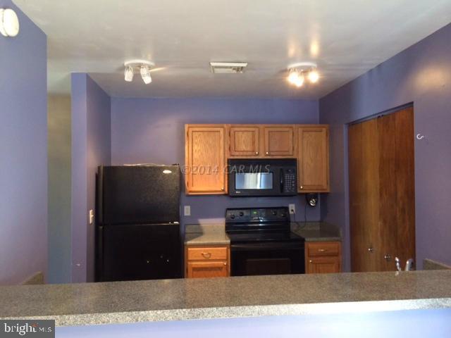 27063 Walnut Tree Road Eden, MD 21822 - Photo 7 of 22 a kitchen with a refrigerator and a stove top oven
