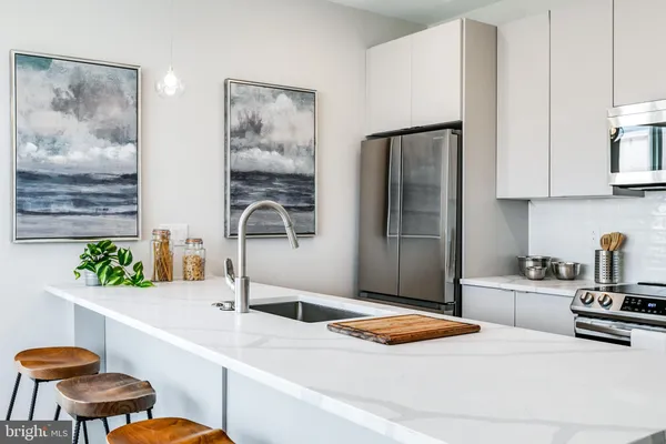 a kitchen with stainless steel appliances granite countertop a sink and a refrigerator