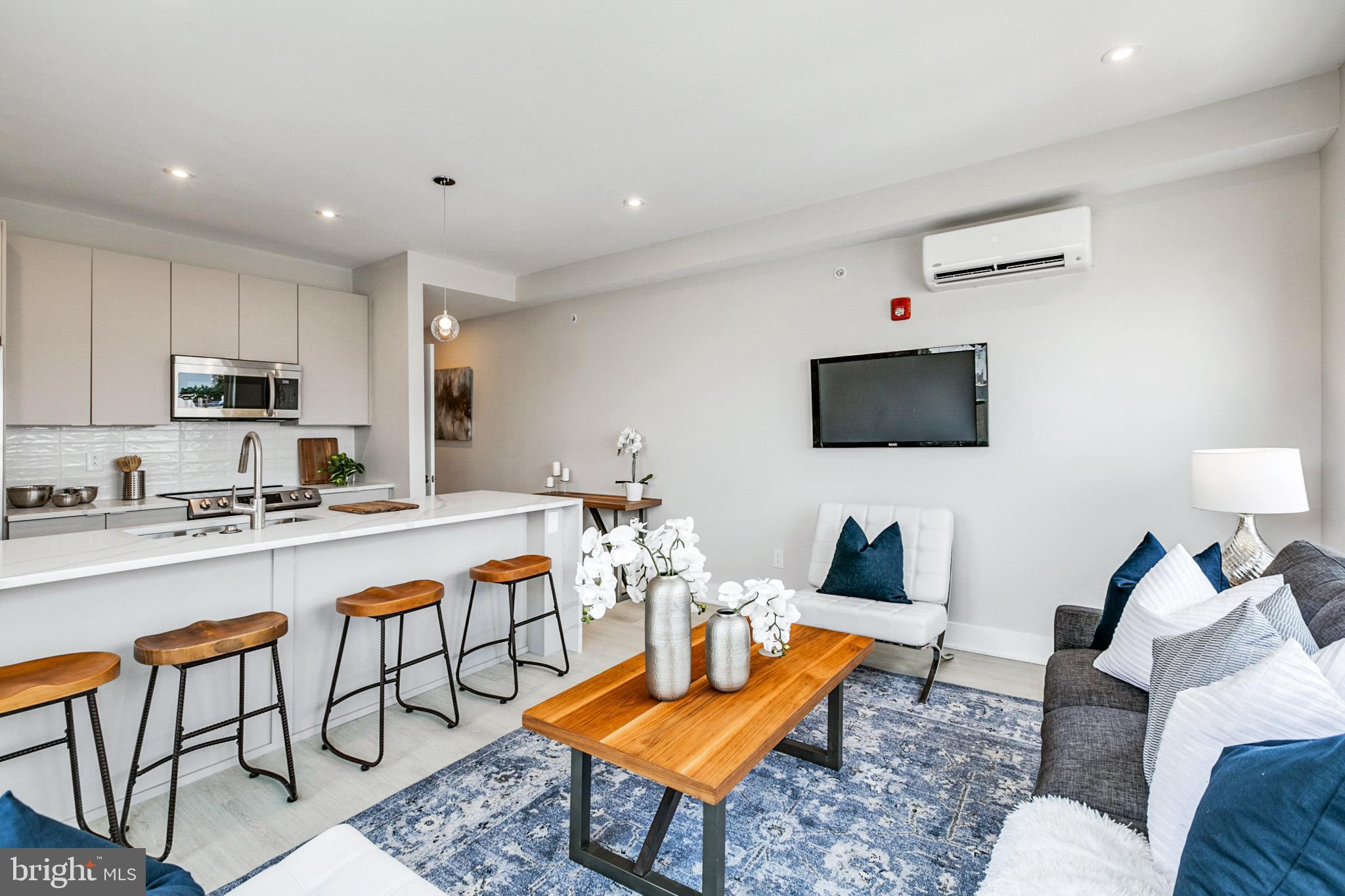 1533 Ridge Avenue, Unit 506 Philadelphia, PA 19130 - Photo 13 of 20 a living room with furniture a flat screen tv and kitchen view