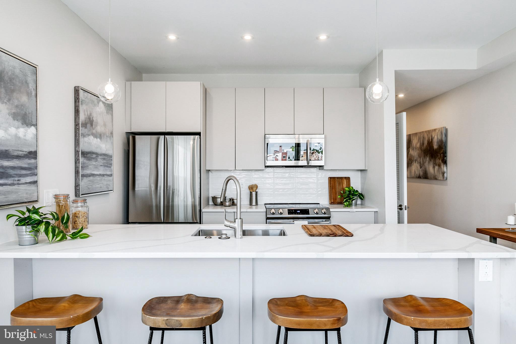 1533 Ridge Avenue, Unit 506 Philadelphia, PA 19130 - Photo 14 of 20 a kitchen with stainless steel appliances a dining table and chairs in it
