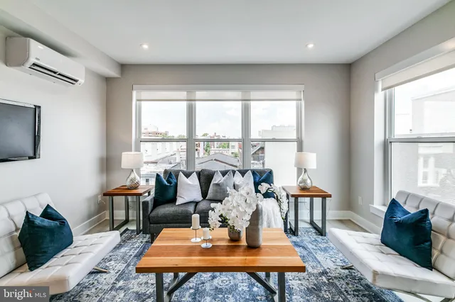 a living room with furniture a table and large windows