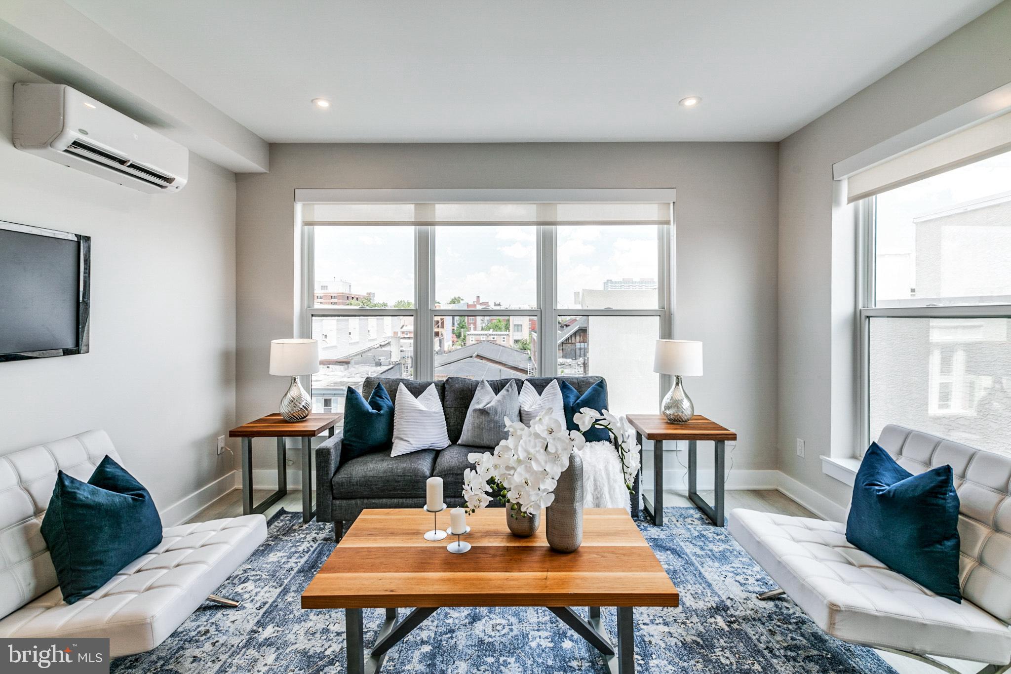 1533 Ridge Avenue, Unit 506 Philadelphia, PA 19130 - Photo 16 of 20 a living room with furniture a table and large windows