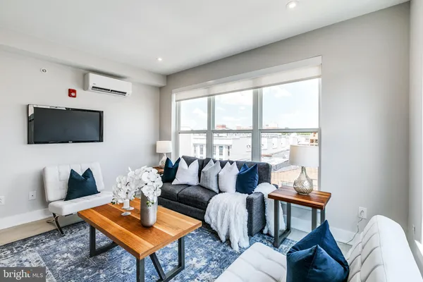 a living room with furniture a flat screen tv and a window