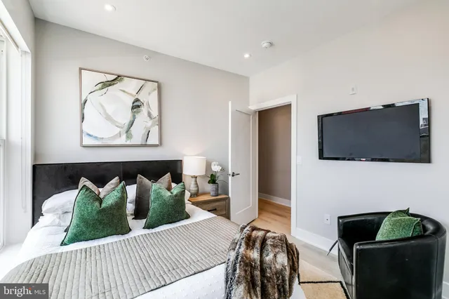 a bedroom with furniture and a flat screen tv
