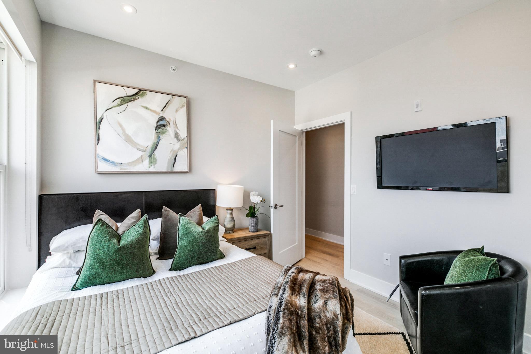 1533 Ridge Avenue, Unit 506 Philadelphia, PA 19130 - Photo 9 of 20 a bedroom with furniture and a flat screen tv