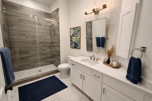 a bathroom with a double vanity sink toilet and shower