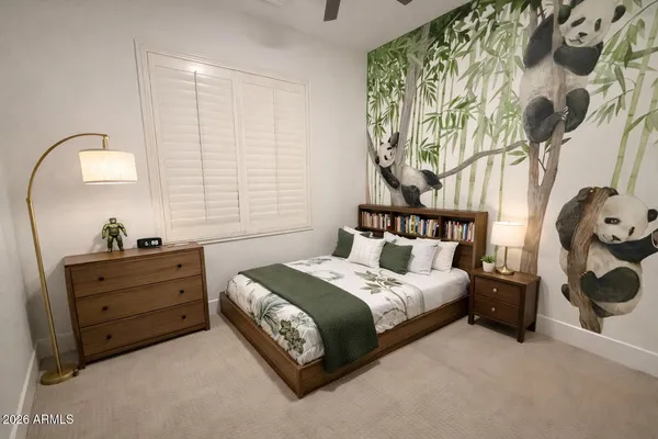 a bedroom with a bed and a mirror on the dresser