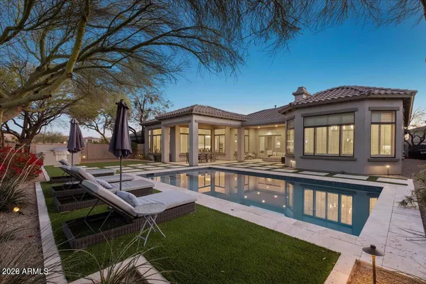 a front view of a house with swimming pool table and chairs