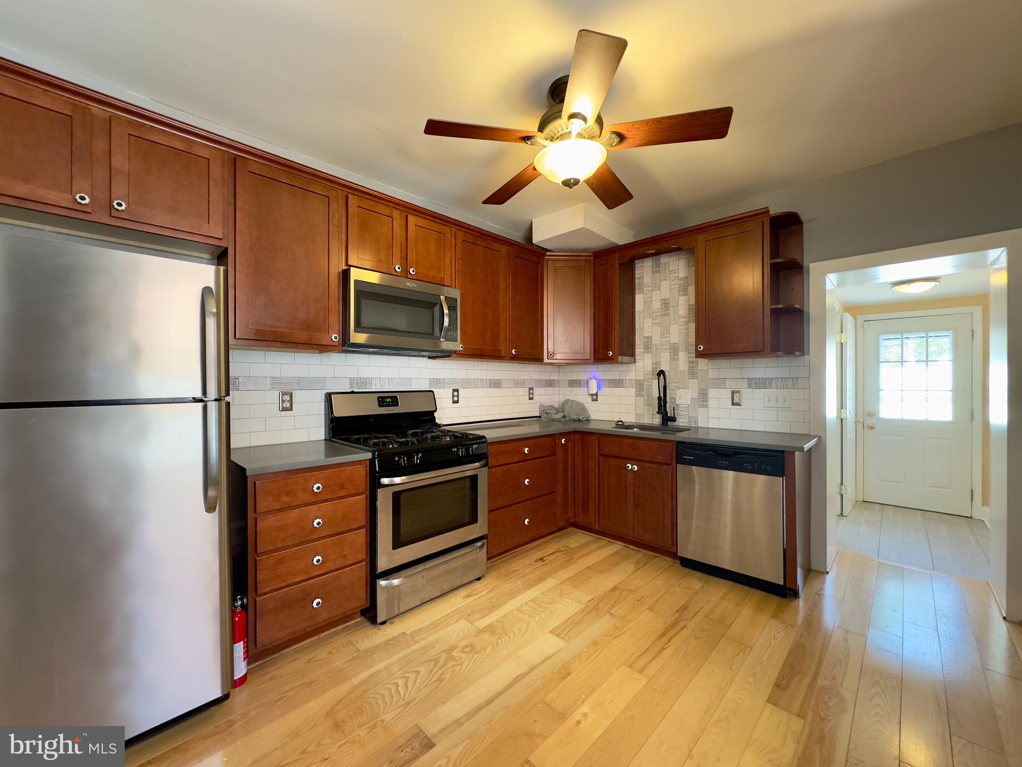 3314 Keswick Road Baltimore, MD 21211 - Photo 4 of 20 a kitchen with stainless steel appliances granite countertop a refrigerator a stove top oven a sink and dishwasher