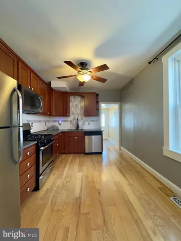 a large kitchen with stainless steel appliances granite countertop a stove and a refrigerator