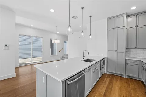 a kitchen with granite countertop a sink a counter space stainless steel appliances and cabinets