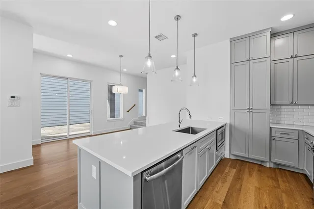 a kitchen with granite countertop a sink a counter space stainless steel appliances and cabinets