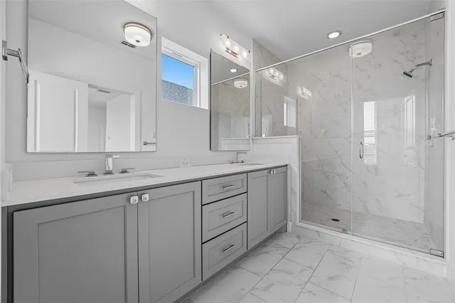 a bathroom with a shower sink and mirror